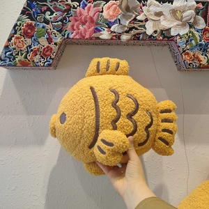 Plush yellow fish shaped throw pillow made of soft curly fleece for home decor