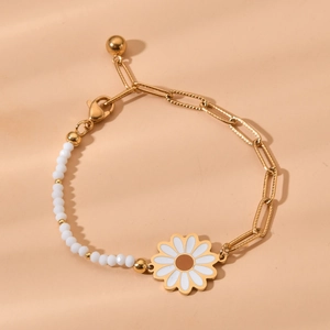 Detail of bohemian daisy charm on golden stainless steel chain with white beads
