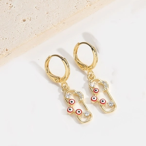 Detail von goldenen Evil Eye Ohrringen mit Halbmond und Sternen auf Steinuntergrund