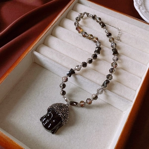 Detail of beaded necklace with black Buddha head pendant and sparkling crystals