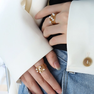 Vintage golden wavy layered rings with pearls on hand for a chic minimalist look