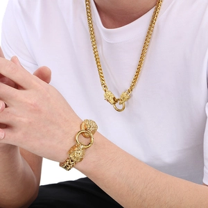Close-up of men's gold lion head buckle necklace and bracelet set on a male model