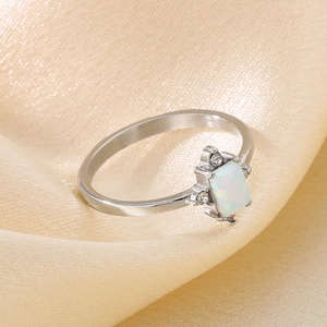 Detailed close-up of a silver-tone ring featuring a rectangular white opal and side zircons