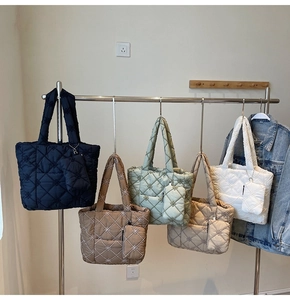 Detail view of five color quilted tote bags with flower embroidery and matching pouches