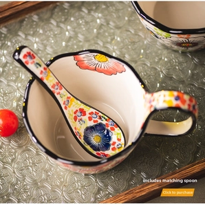 Detail of hand-painted ceramic bowl and matching spoon with vibrant floral pattern