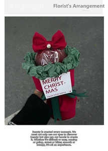 Close-up of Christmas apple gift bouquet with red knit bow, pearls and festive greeting card