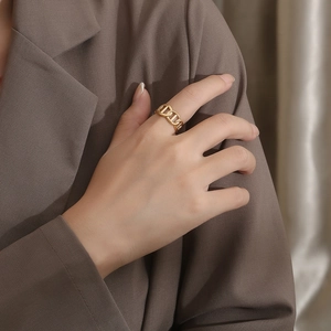 Macro shot of gold-plated chain link ring on finger with elegant minimalist aesthetic