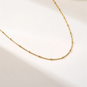 Detailed view of a gold satellite chain necklace with delicate beads and mirror finish