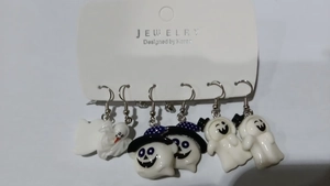 Détail de trois paires de boucles d'oreilles fantômes d'Halloween sur une carte de bijoux