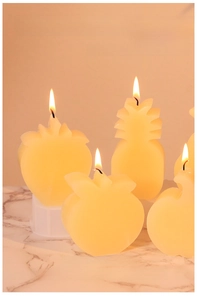 Detail view of fruit shaped candles like pineapple and strawberry made with silicone mold