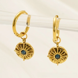 Detail of gold hoop earrings with sunburst charms and blue center stone inlay
