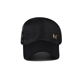 Casquette de baseball classique en satin noir avec logo M métallique doré sur fond blanc