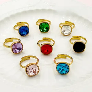 Détail de huit bagues en cristal de forme carrée colorée avec monture dorée réglable