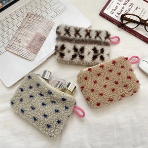 Fleece cosmetic pouch detailing plush texture and zipper closure for storage
