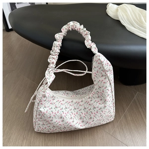 Floral print crescent shoulder bag with ruched strap and silver zipper closure