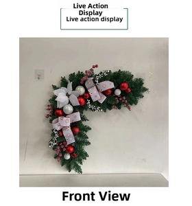 Detail of Christmas corner swag featuring red baubles, white flower and festive pine