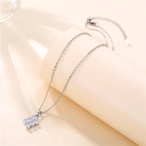 Detailed view of silver square pendant with six clear zircons on an O-chain necklace