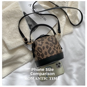 Mini leopard print cylinder bag shown next to a smartphone for size reference