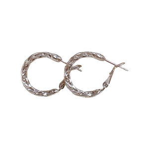 Minimalist silver twist hoop earrings with irregular hammered texture on white background