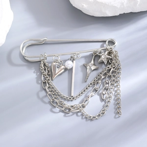 Detail of silver chain brooch with heart, star charms and pearl on safety pin
