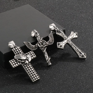 Detailed shot of Gothic silver steel crosses with prayer hands, roses, and wings motifs