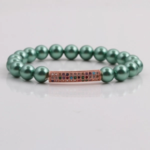 Détail du bracelet en perles de coquillage vert foncé avec tube courbé en zircon rose