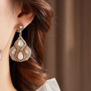 Détail de boucles d'oreilles vintage en opale sur un mannequin au style élégant