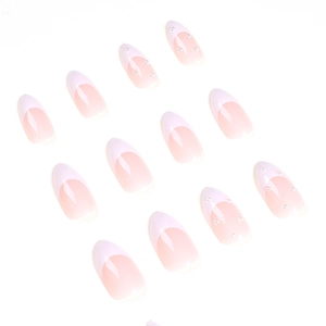 Faux ongles French manucure rose doux avec bordures blanches et perles élégantes