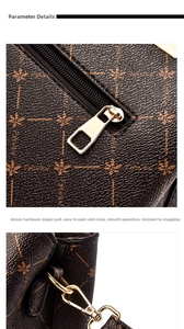Detail of smooth gold zipper and maple leaf print on dark brown leather tote bag