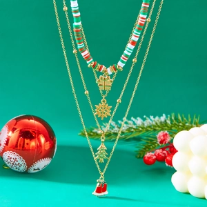 Detail of Christmas multi-layer beaded necklace with colorful pendants on green background