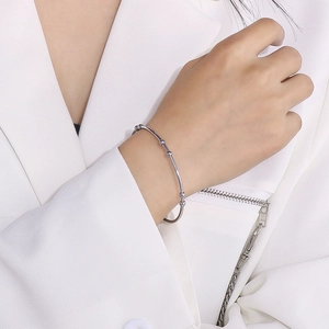 Detailed view of silver stainless steel cuff bracelet with bead accents on model