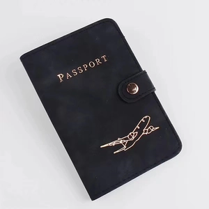 Detail of black PU leather RFID passport holder with gold airplane and snap closure