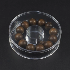 Close-up of wooden beads bracelet inside a round transparent display gift box