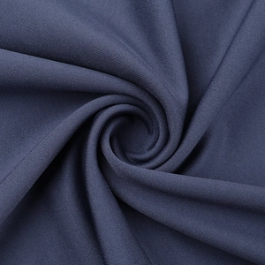 Macro shot of dark grey-blue knit fabric texture and drape detail on a long sleeve dress