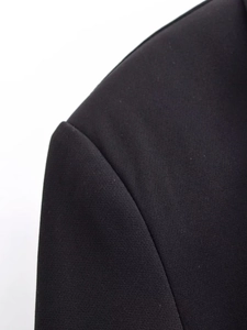 Close-up of shoulder stitching and premium woven texture on a black blazer dress