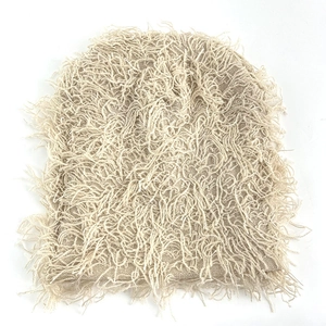 Detailed texture of beige knitted beanie featuring unique fluffy fringe tassel design
