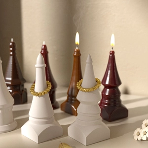 Golden geometric chain and bubble bead rings on a white stone spire display stand