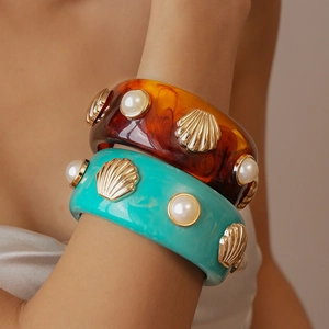 Detailed shot of resin wide bangle set with amber tortoiseshell finish and pearl inlay