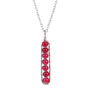 Detail of silver wire wrapped pendant with seven red crystal beads on a necklace