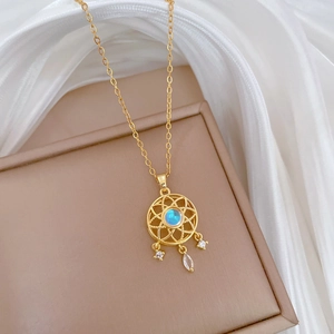 Detail of dreamcatcher pendant with opal and zircons on a white silk background