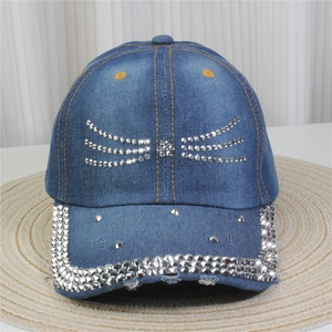 Détail de la casquette en jean avec nœud en strass et bordure étincelante