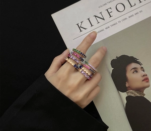 Close-up of colorful 4mm cubic zirconia eternity rings stacked on a hand