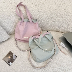 Detailansicht der Nylon-Einkaufstaschen in Rosa und Grün mit Kordelzug und Webriemen