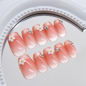 Champagnerfarbene Nägel zum Aufdrücken mit weißen 3D-Blumen und glitzerndem Cat-Eye-Effekt