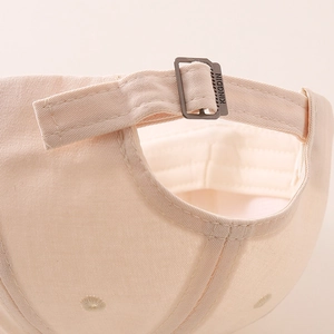 Detail of adjustable metal buckle with KINGDIN engraving on beige cotton baseball cap