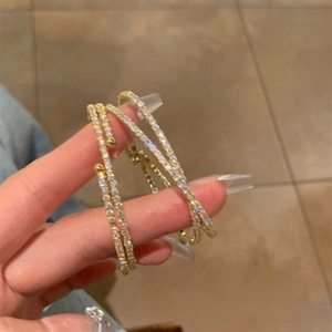 Grandi orecchini a cerchio dorati con zirconi brillanti e design intrecciato