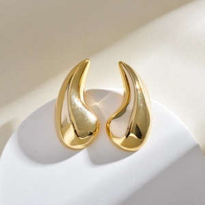 Macro detail of polished 18K gold plated water-drop earrings with an irregular design