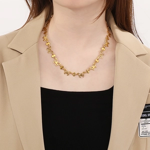 Close-up of golden butterfly link necklace worn by model showing exquisite craftsmanship