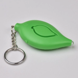 Close-up of green leaf-shaped personal alarm with metal keychain and built-in LED light