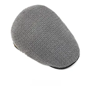 Top view of grey knitted newsboy cap showing detailed woven texture and flat brim